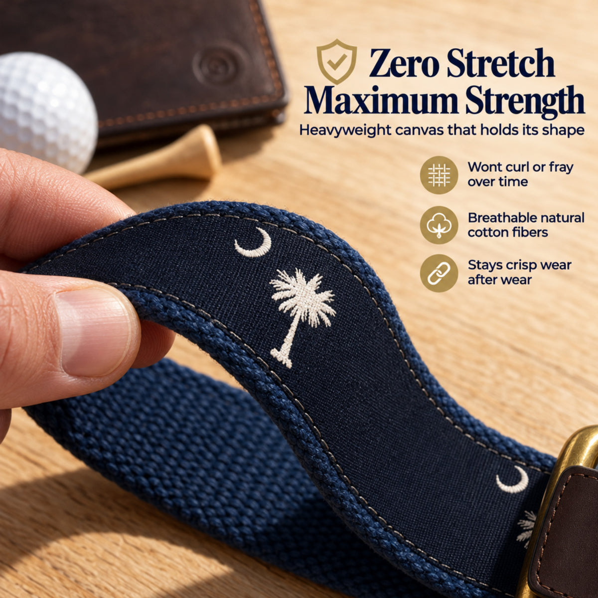A close-up of a navy blue woven canvas belt with a white embroidered palm tree and crescent moon motif, held by a hand over a wooden surface. The image includes marketing text and icons highlighting zero stretch, maximum strength, breathable natural cotton fibers, and shape retention. sc flag belt.