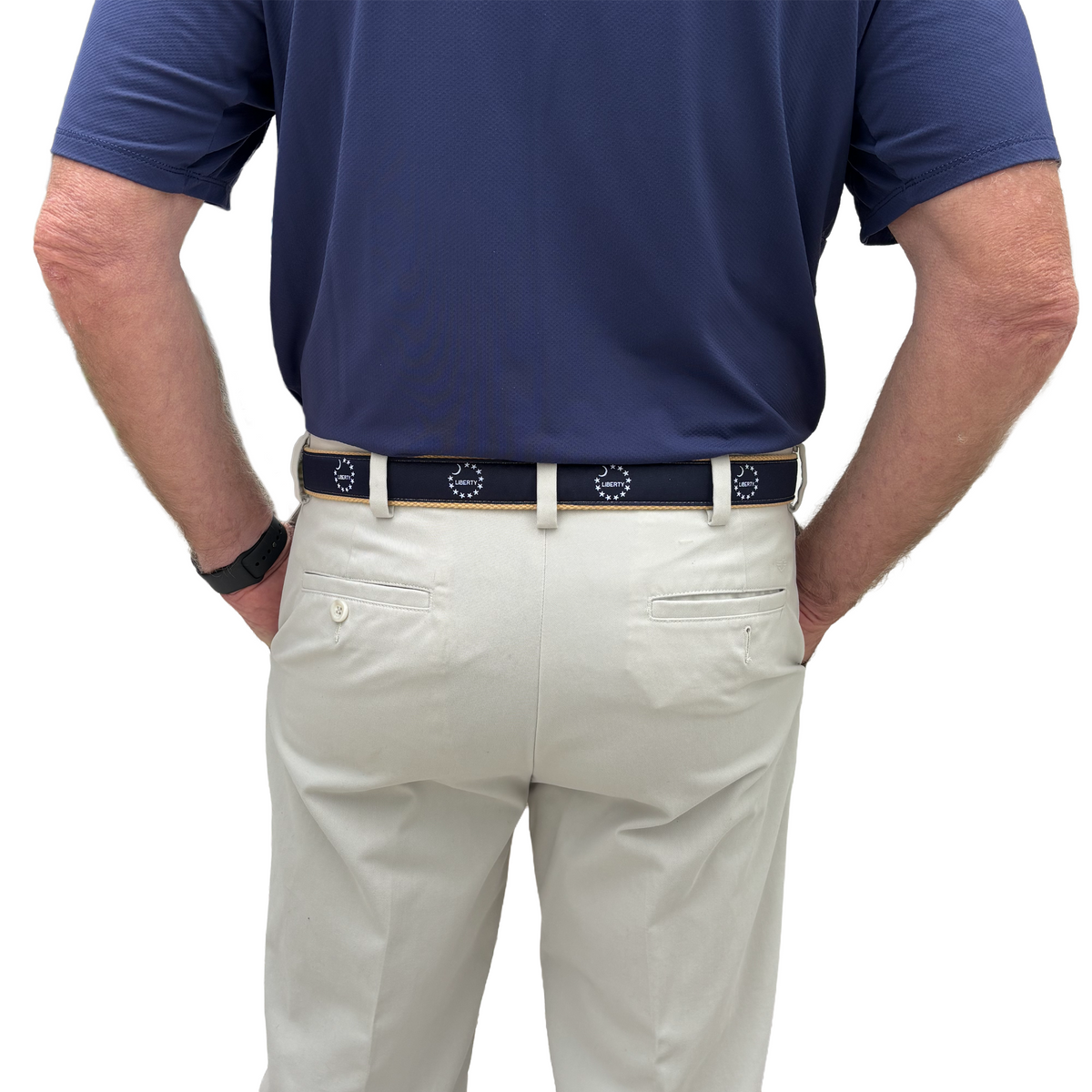 Person wearing a blue shirt and beige pants with a belt on a white background featuring the word "Liberty" and the south carolina crescent moon. also with circular stars from the betsy ross flag.