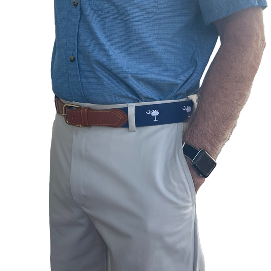 Person wearing a blue shirt, gray pants, and a belt with sc state flag design palmetto tree and moon 
